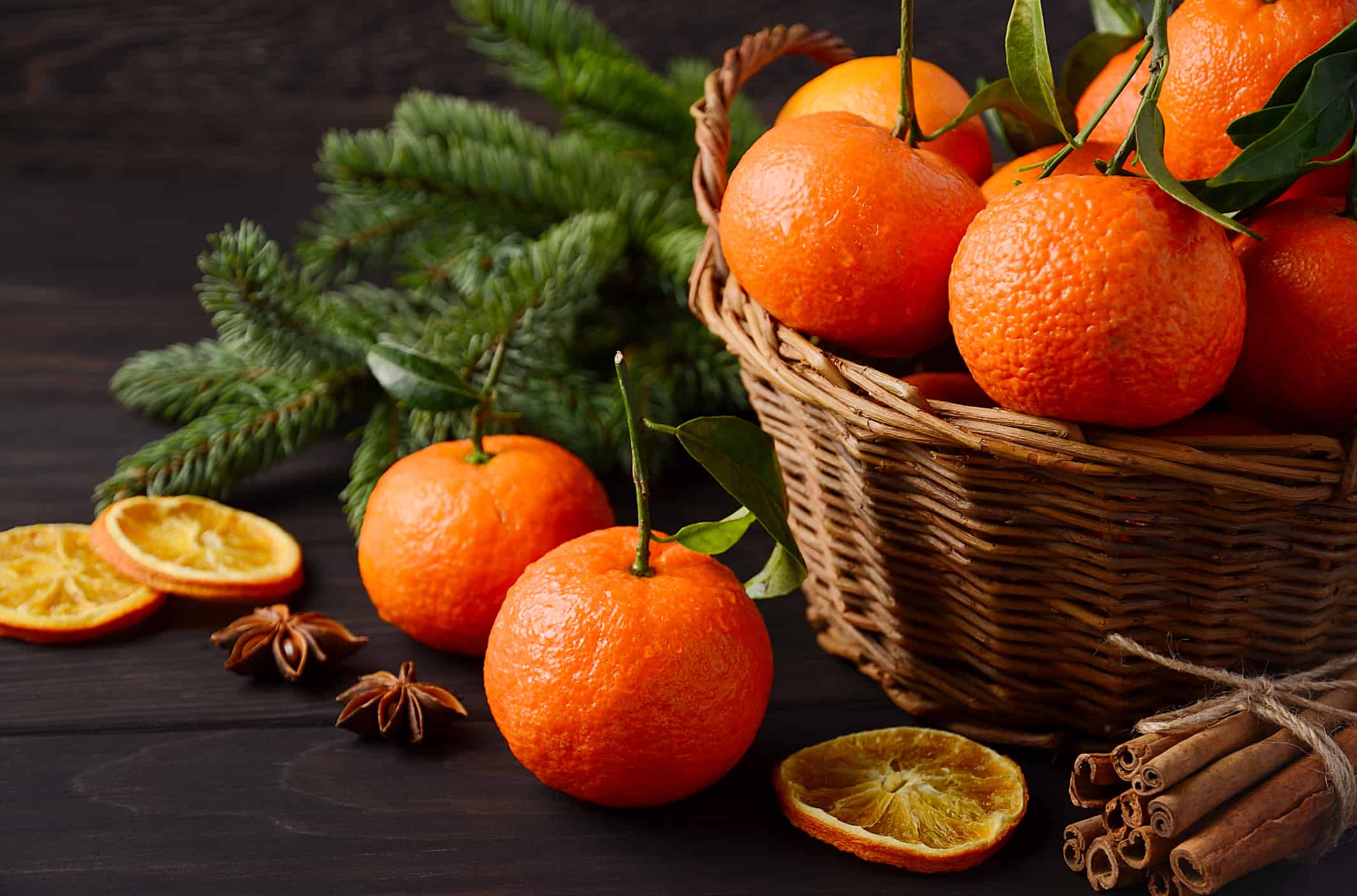 Clementine mandarino fresche con spezie su sfondo di legno scuro, concetto di Natale.