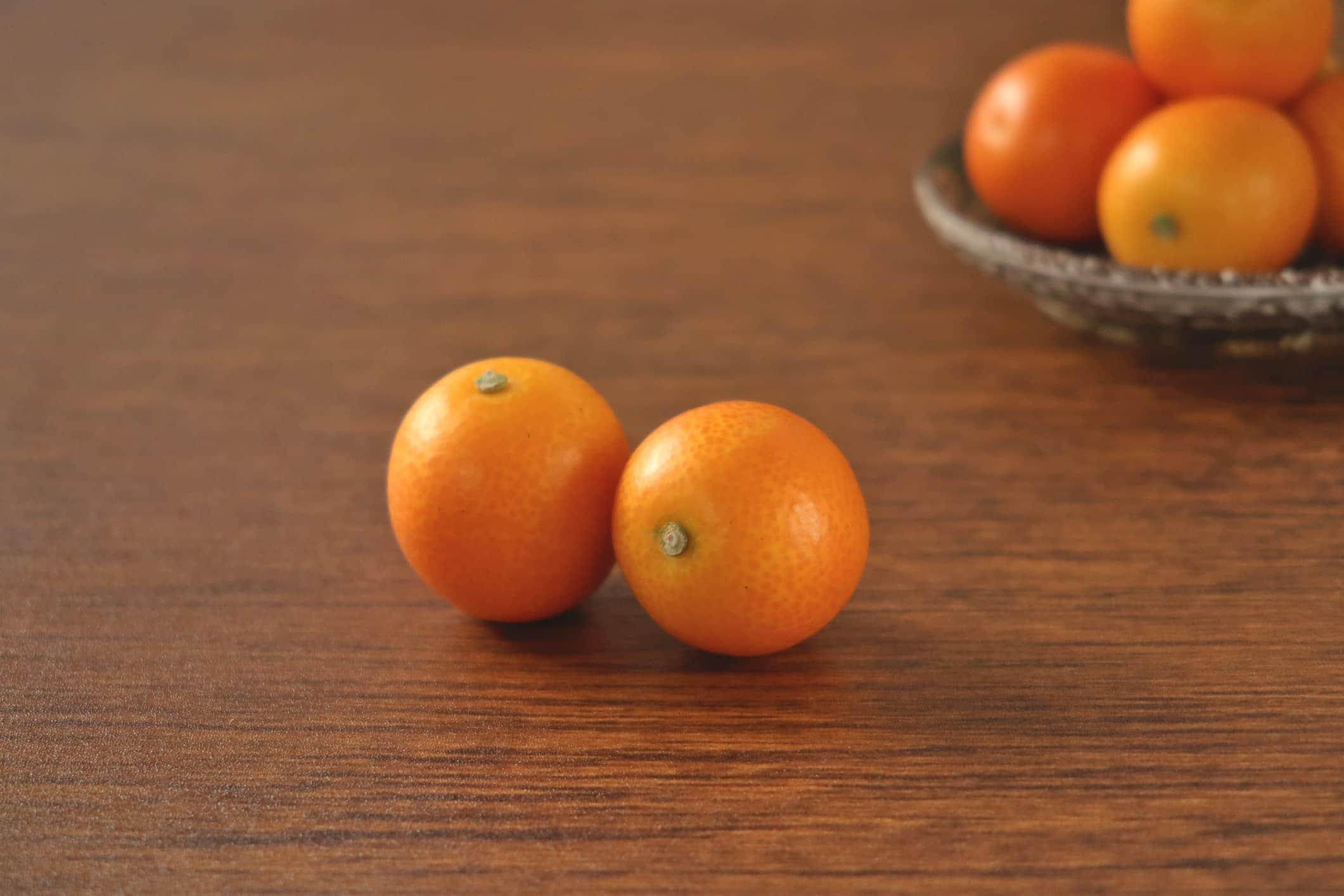 Ci sono kumquat sul tavolo e nel piatto.