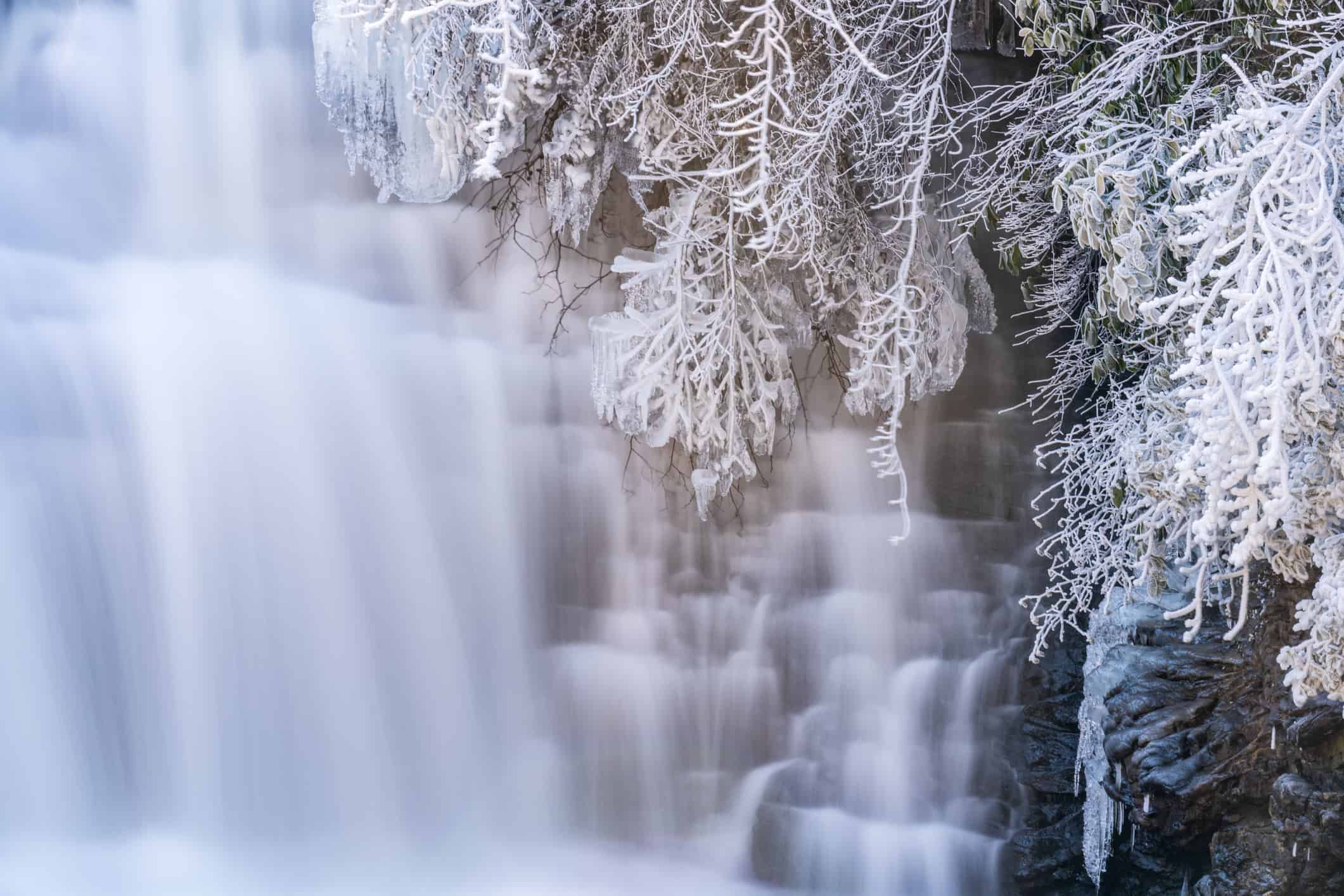Scena invernale delle cascate Desoto che precipitano su uno sperone roccioso in una foresta gelida, Alabama