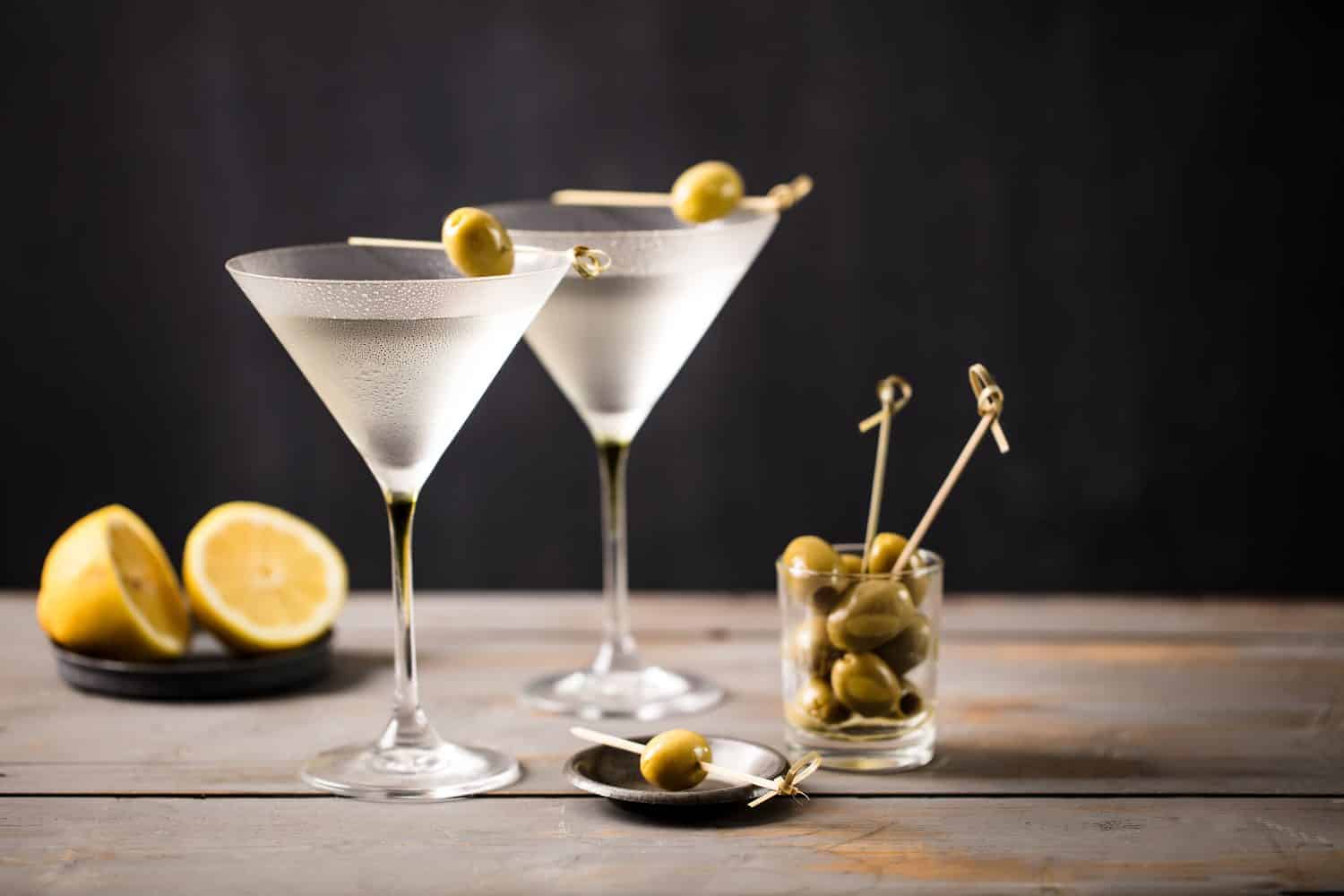 Cocktail Martini sul piano di lavoro in legno.  Guarnizione di olive.  Spazio per il testo