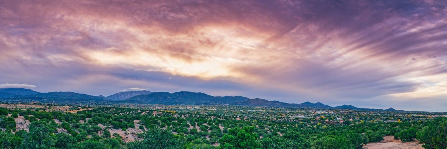 Sole che attraversa le nuvole sulle montagne del Sangre de Cristo e Santa Fe nel New Mexico 