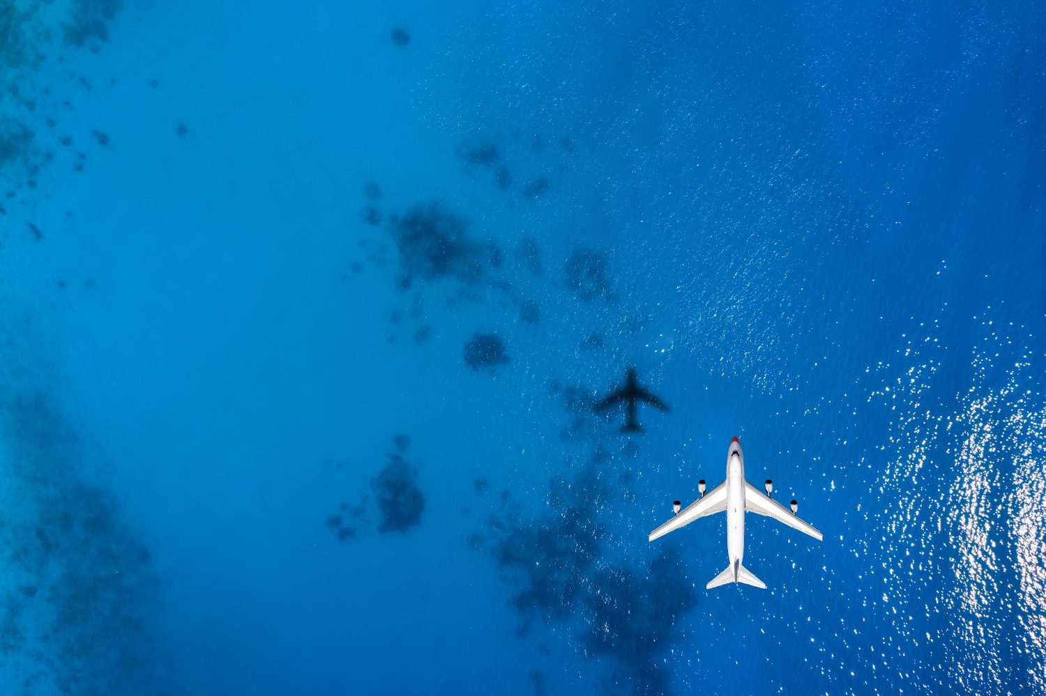 Vista aerea dall'alto verso il basso di un aereo che sorvola il mare blu come concetto di viaggio con spazio per la copia