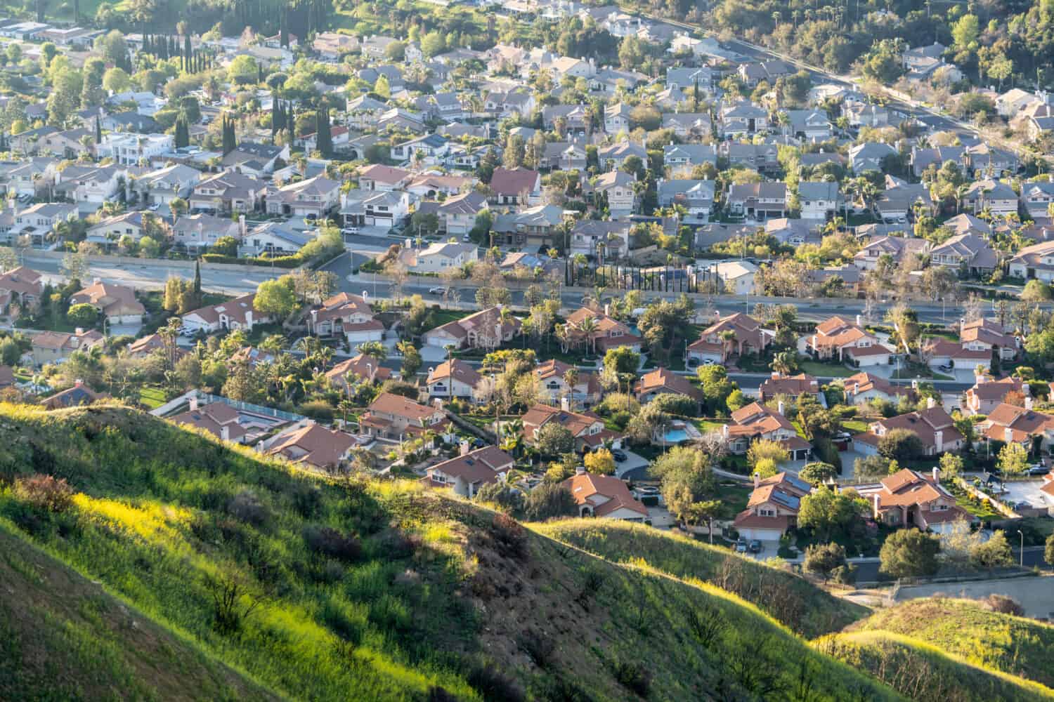 Pendii montani e case nella valle nella zona delle colline di Granada, a nord di Los Angeles, California.