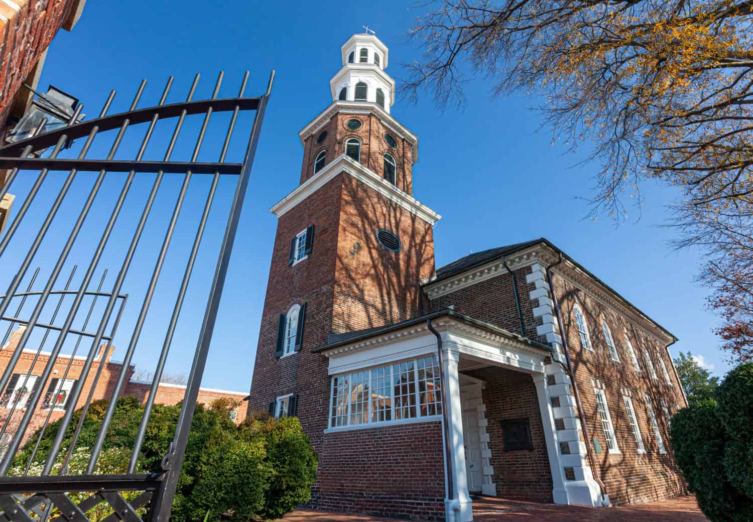 Immagine ravvicinata dell'ingresso della storica Christ Church.  Questo edificio in mattoni con torre fu costruito nel 1773 come principale chiesa d'Inghilterra del quartiere.  Davanti c'è un alto cancello di metallo