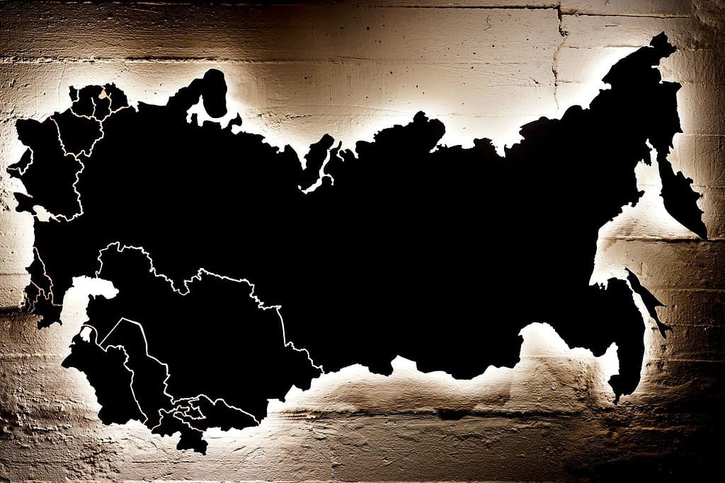 Una mappa nera di Russia, Ucraina e 15 repubbliche dell'Unione Sovietica appesa a un muro rotto