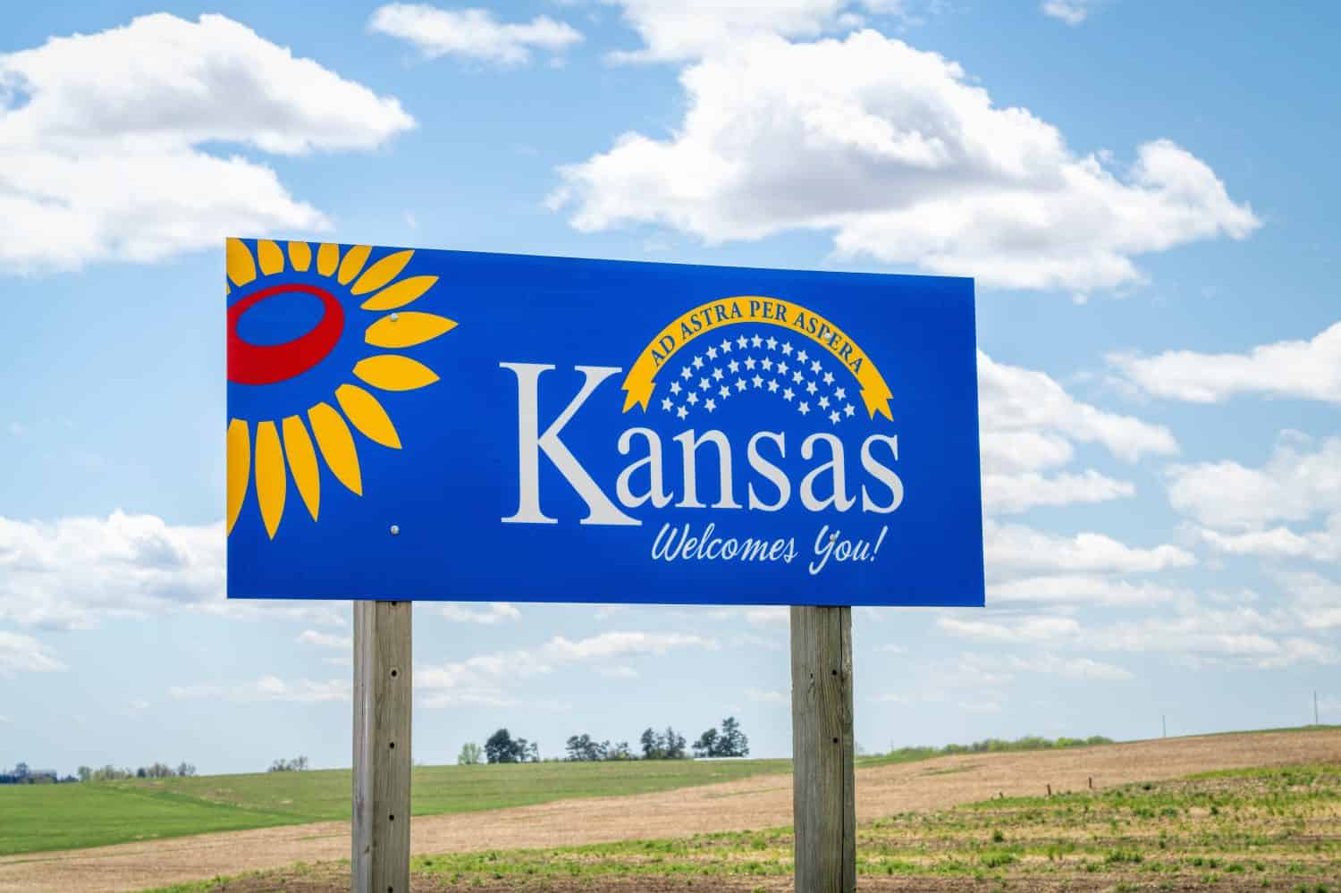 Il Kansas ti dà il benvenuto: cartello stradale di benvenuto con una popolare frase latina ad astra per aspera (attraverso le difficoltà fino alle stelle), concetto di guida e di viaggio