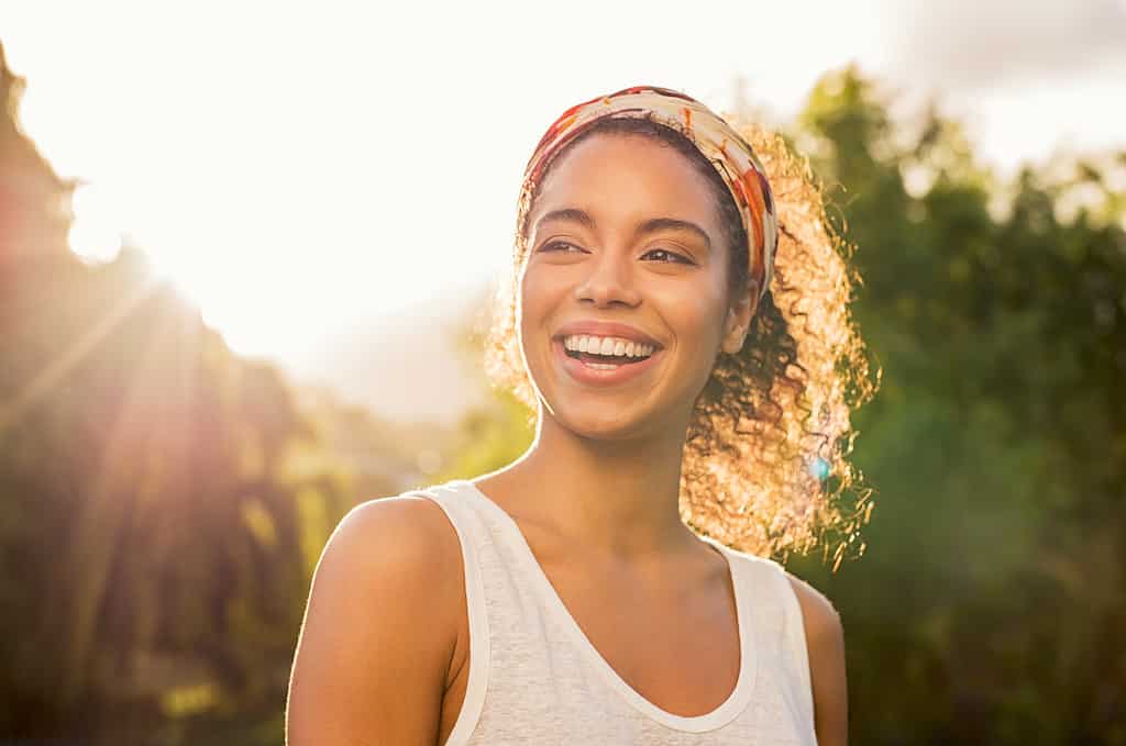 Giovane donna africana che sorride al tramonto