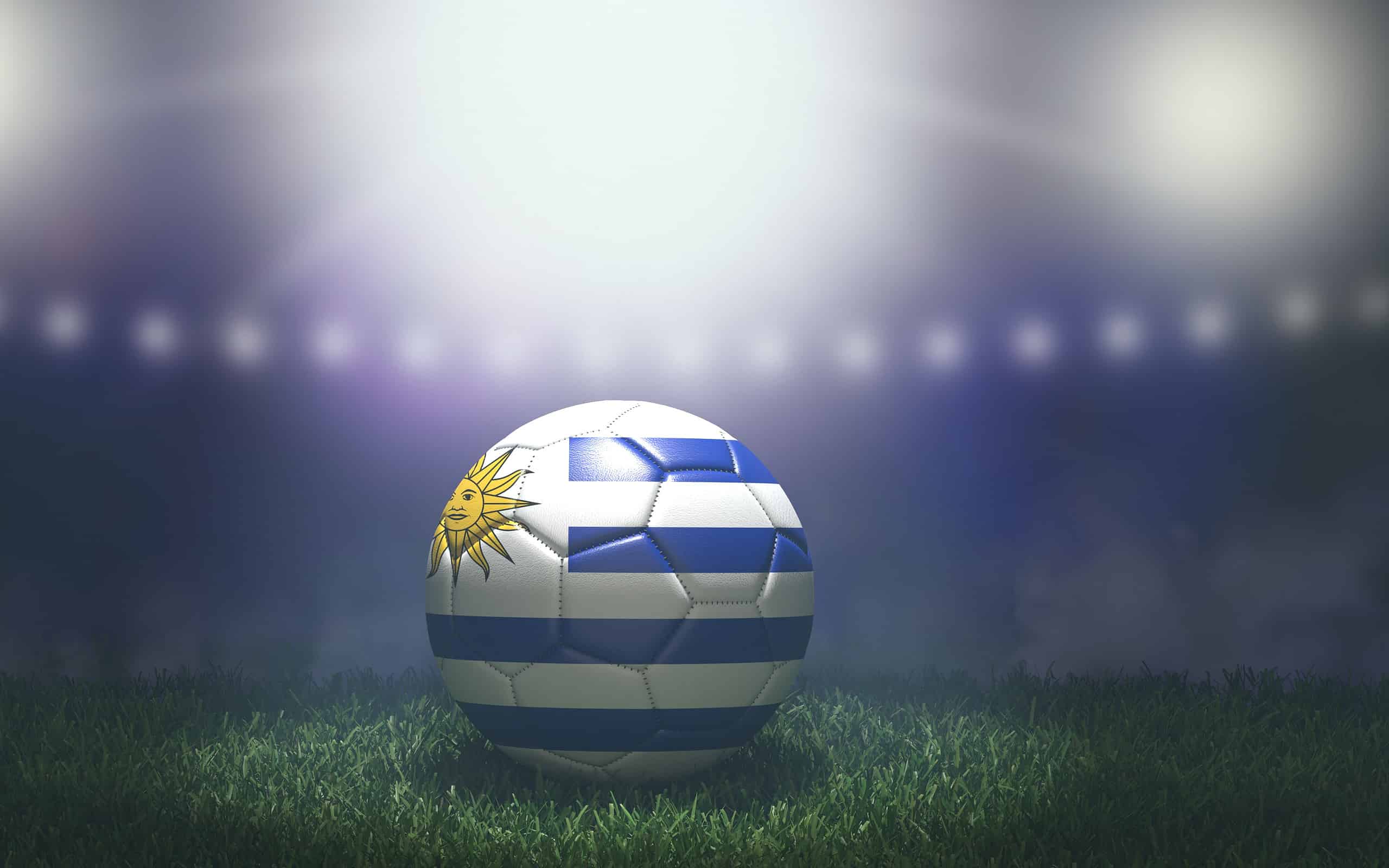 Pallone da calcio nei colori della bandiera su uno sfondo luminoso e sfocato dello stadio.  Uruguay.