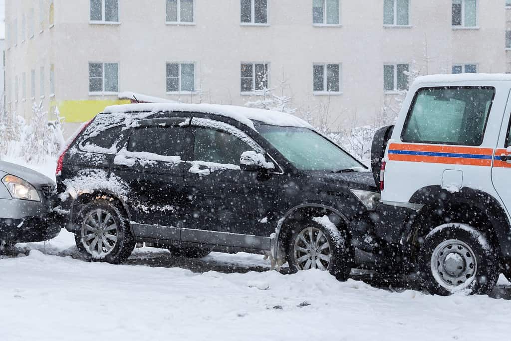 Incidente stradale in una strada cittadina.  Diverse auto si sono schiantate su una strada scivolosa e coperta di neve.  Condizioni stradali difficili durante le nevicate.  Tempo invernale nevoso.