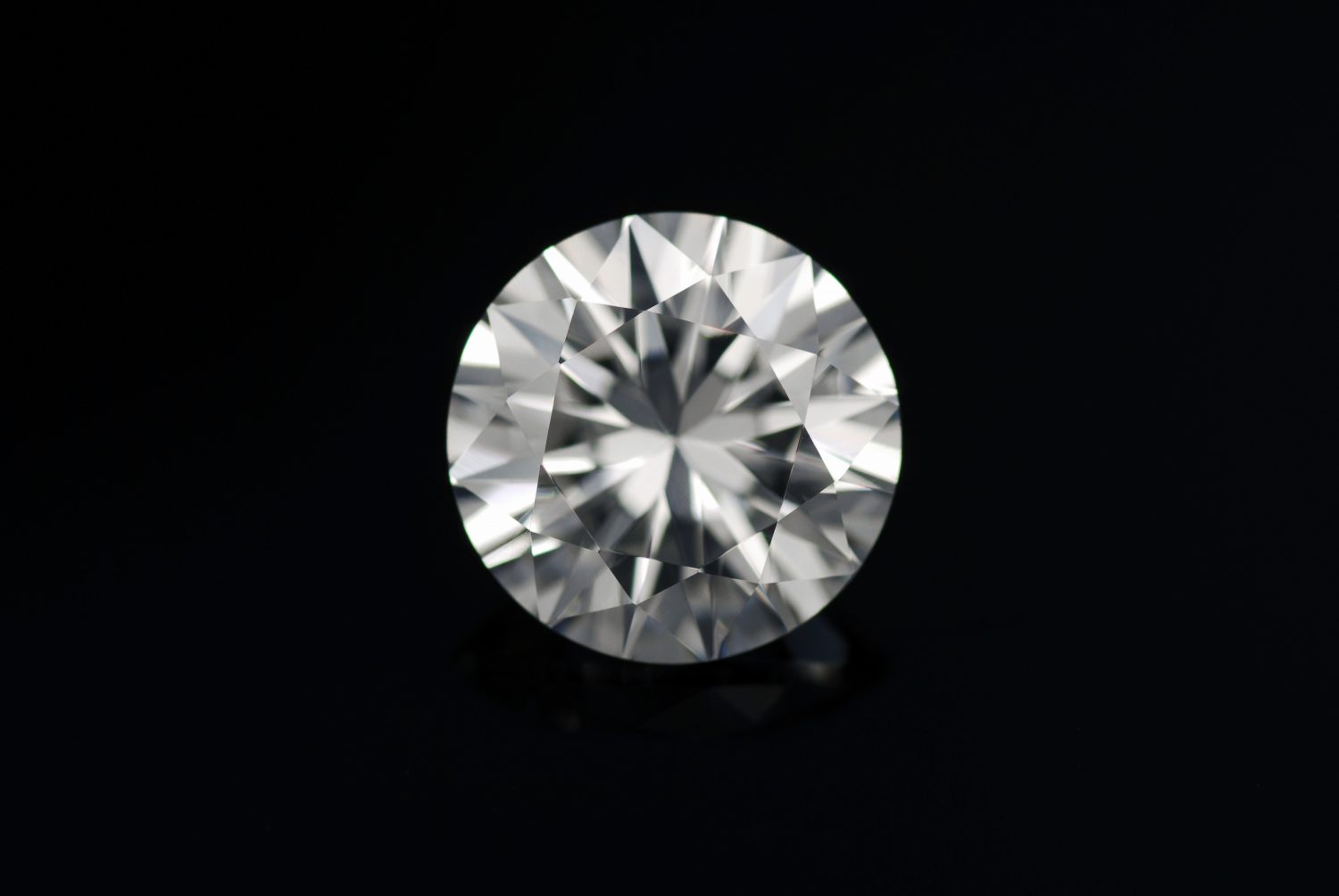 Zirconia cubica sfaccettata con diamante rotondo, forma cristallina cubica di materiale sintetizzato incolore di biossido di zirconio (ZrO2).  Pietra preziosa sintetica bianca.  Imitazione del diamante.  Sfondo nero isolato.
