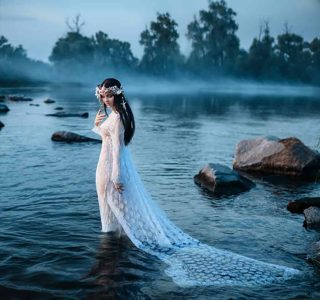 Signora lussuosa, in elegante abito lungo in mezzo al lago