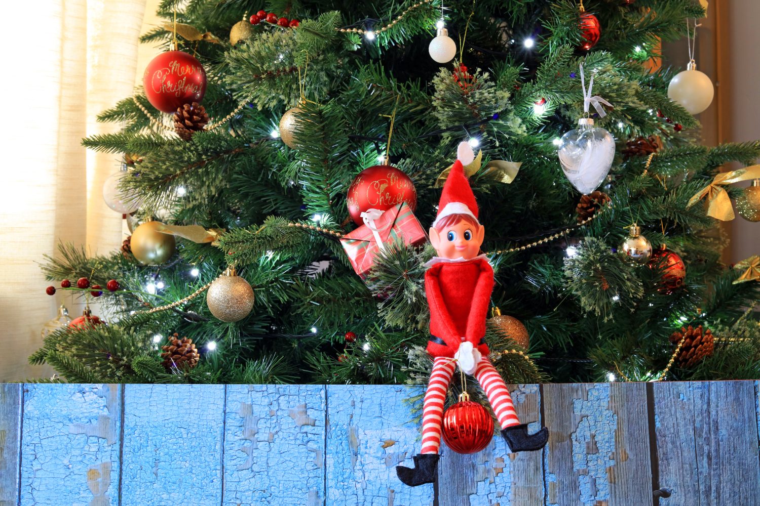 Elfo Dispettoso Sullo Scaffale Seduto Su Un Ramo Di Un Albero Di Natale Con Una Pallina.