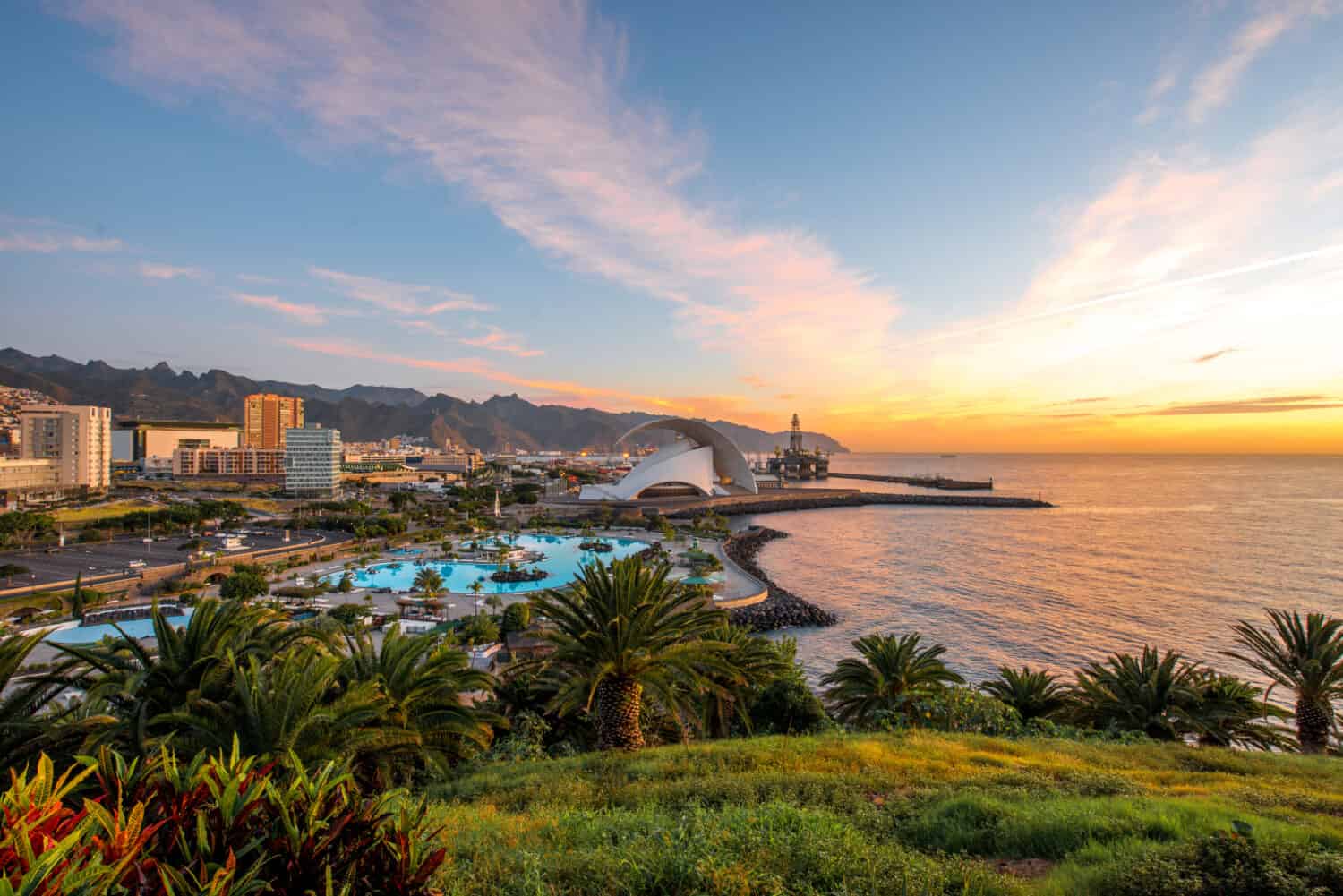 Vista sul paesaggio urbano di Santa Cruz con parco, oceano e montagne sullo sfondo all'alba, Isole Canarie, Spagna