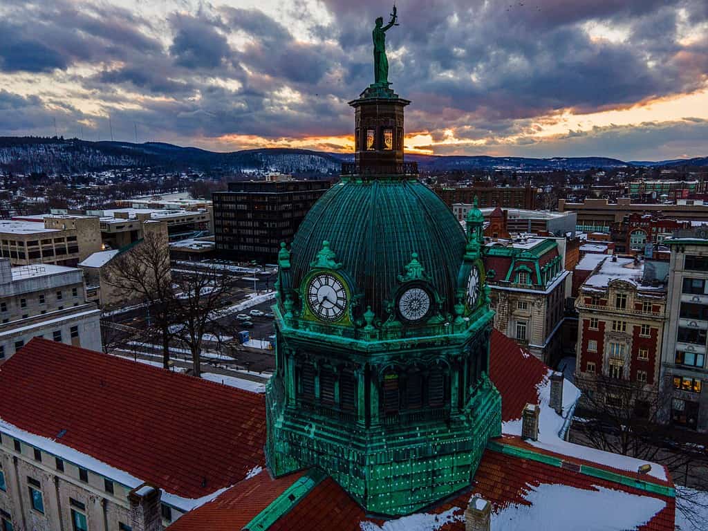 Una ripresa aerea di un tempio verde nel centro di Binghamton, durante un tramonto arancione