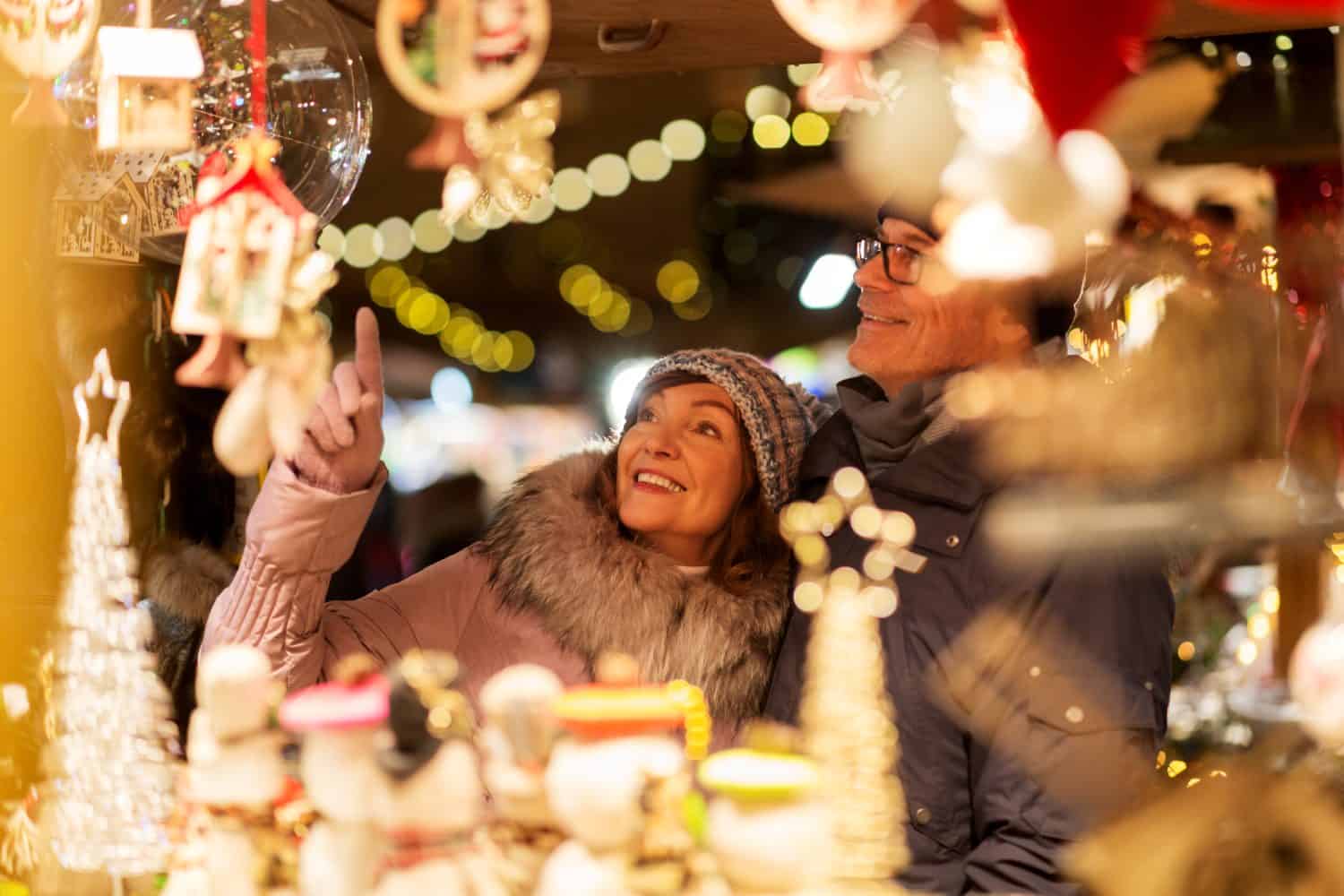 shopping, vacanze invernali e concetto di persone - coppia senior felice al negozio di souvenir del mercatino di natale sulla piazza del municipio a tallinn, estonia