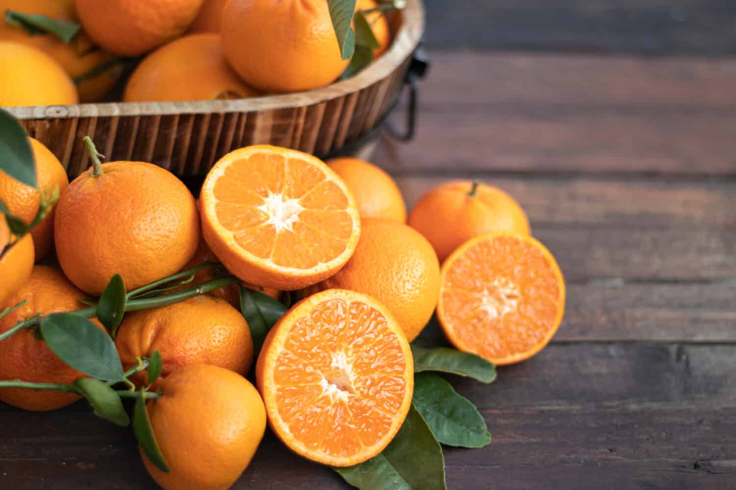 Frutta arancione con foglie verdi sul legno.  Giardinaggio domestico.  Arance mandarine.  Arance mandarini.  Colore arancione.  Succo d'arancia fresco.
