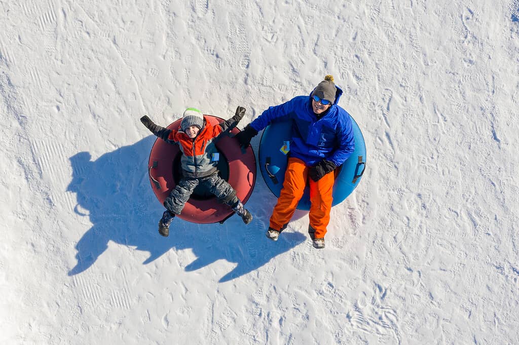 Padre e figlio snow tubing in inverno in Canada