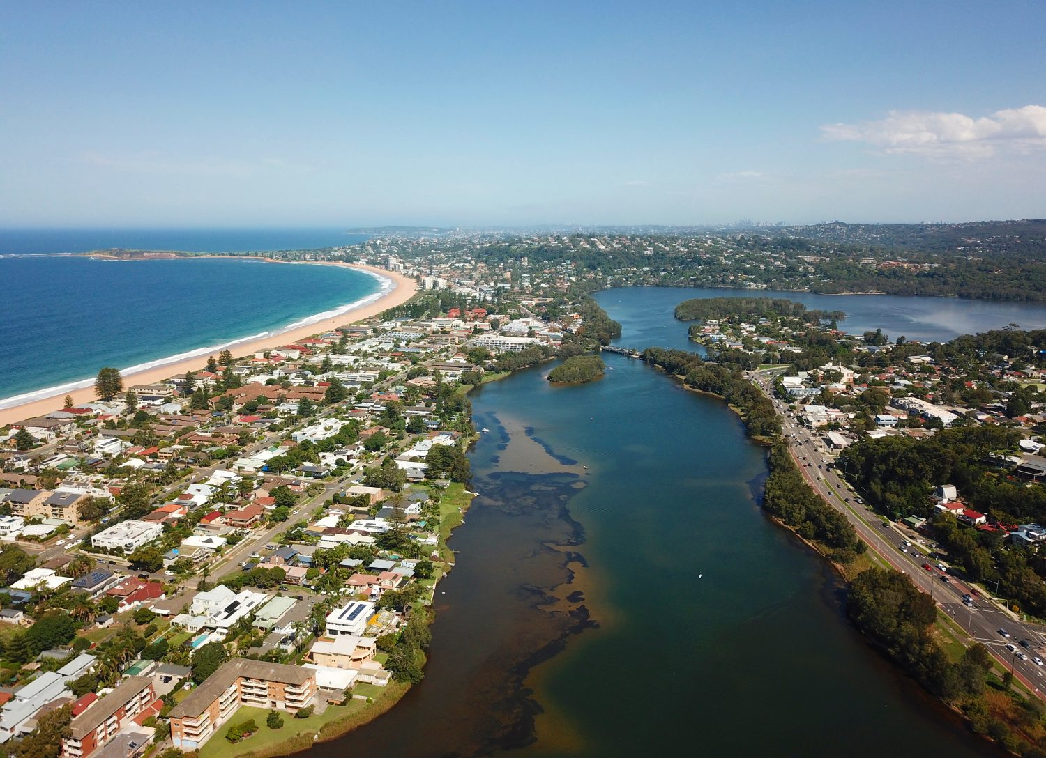 Veduta aerea del lago Narrabeen, della spiaggia di Narrabeen, della spiaggia di Collaroy e di Long Reef Head.  Sullo sfondo il CBD di Sydney.