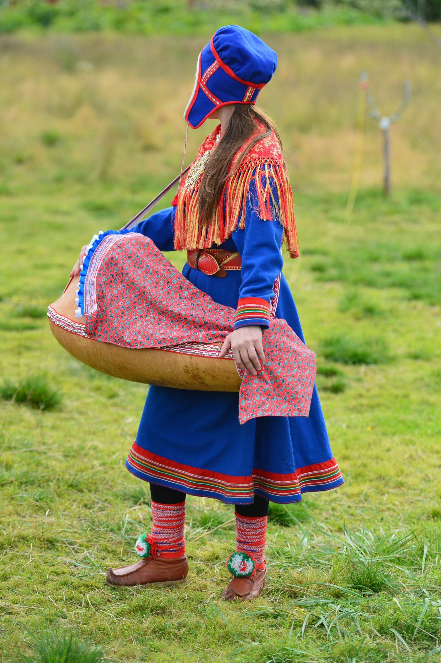 La Norvegia settentrionale, una donna Sami vestita tradizionale con una culla