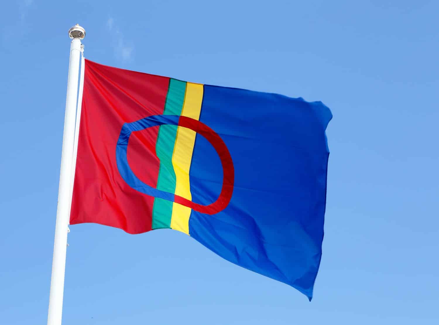 La bandiera Sami isolata sul cielo blu chiaro.