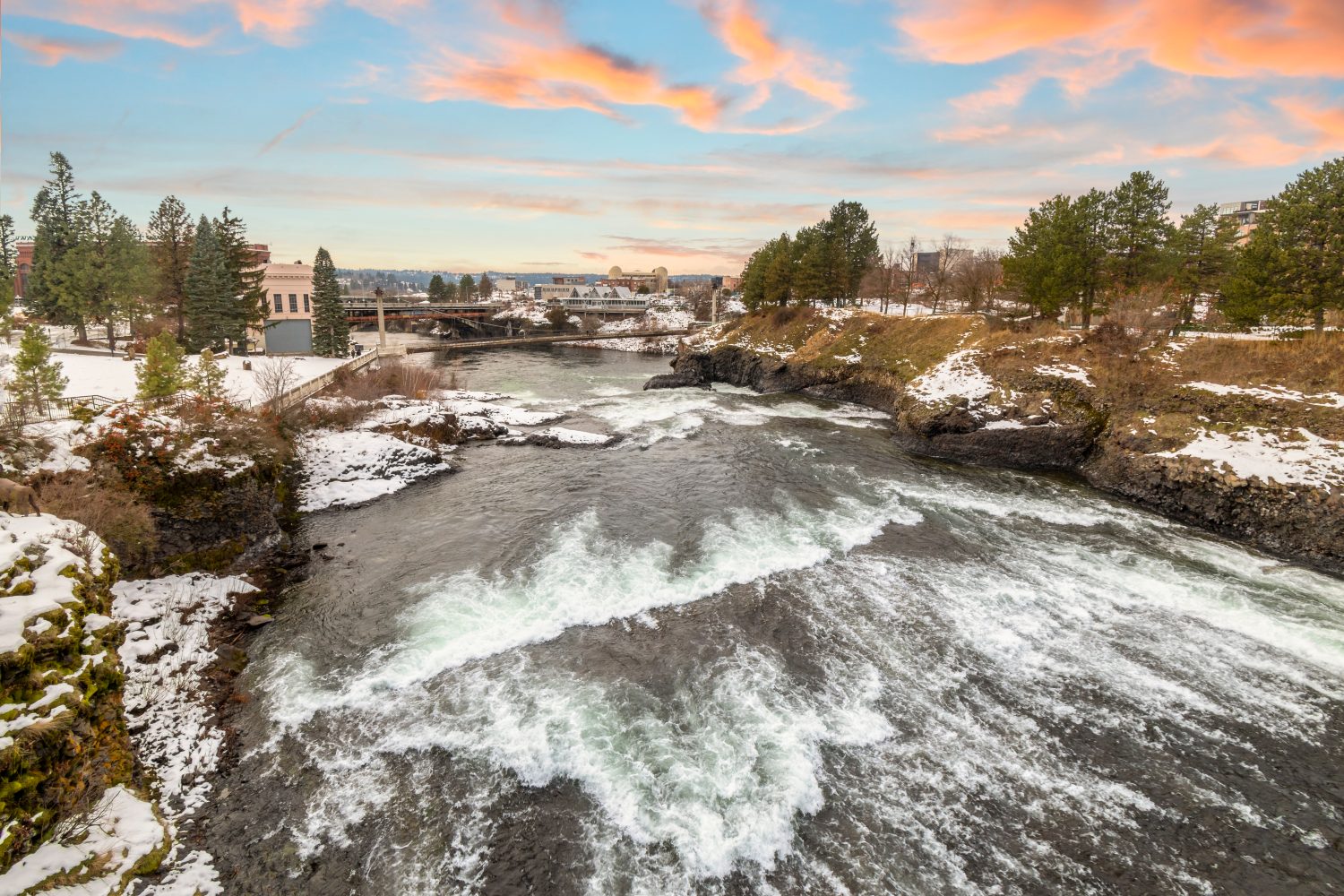 Il Post Street Bridge e la diga al Riverfront Park durante un inverno nevoso al tramonto a Spokane, Washington.