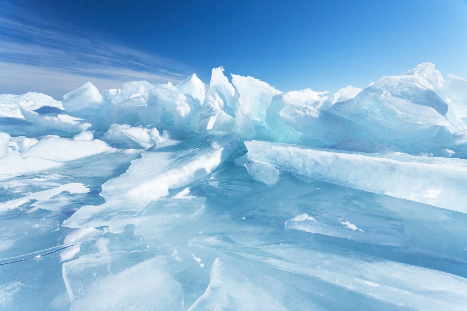 Sfondo naturale invernale con frammenti di ghiaccio blu e cumuli di pezzi di ghiaccio sul lago Baikal in una giornata gelida e soleggiata.  Sfondo freddo astratto, mock up.  Ambiente duro e senza vita