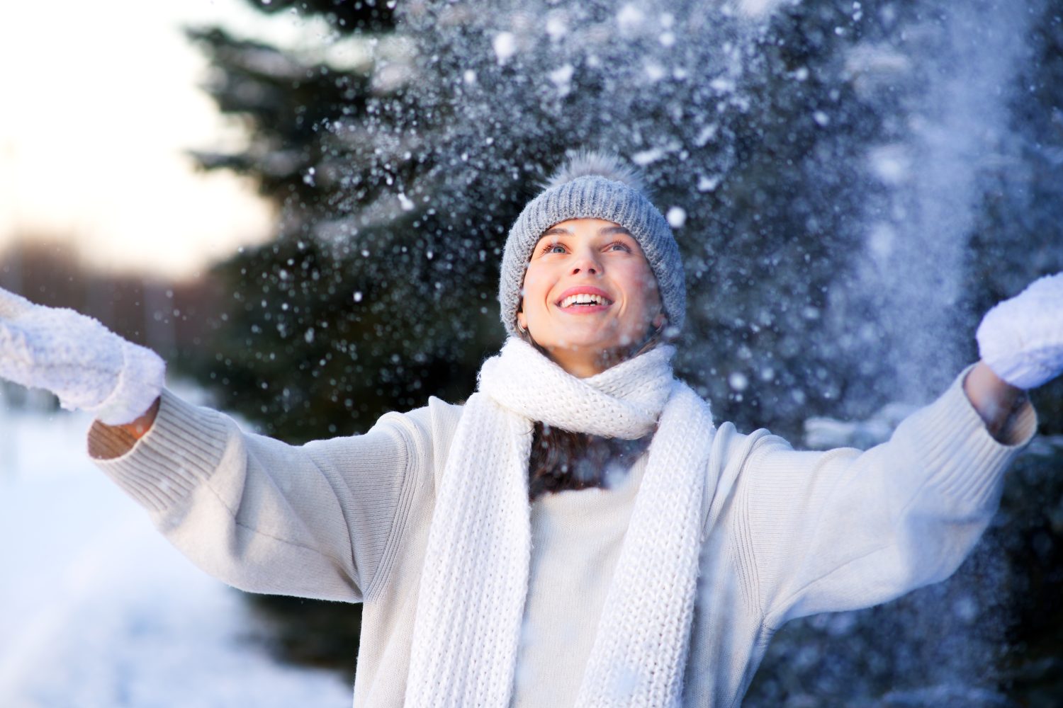 Ritratto di bella ragazza felice, giovane donna gioiosa positiva che cammina giocando con la neve, i fiocchi di neve, divertendosi all'aperto in abiti invernali, cappello e sciarpa, sorridente.  Stagione invernale, meteo
