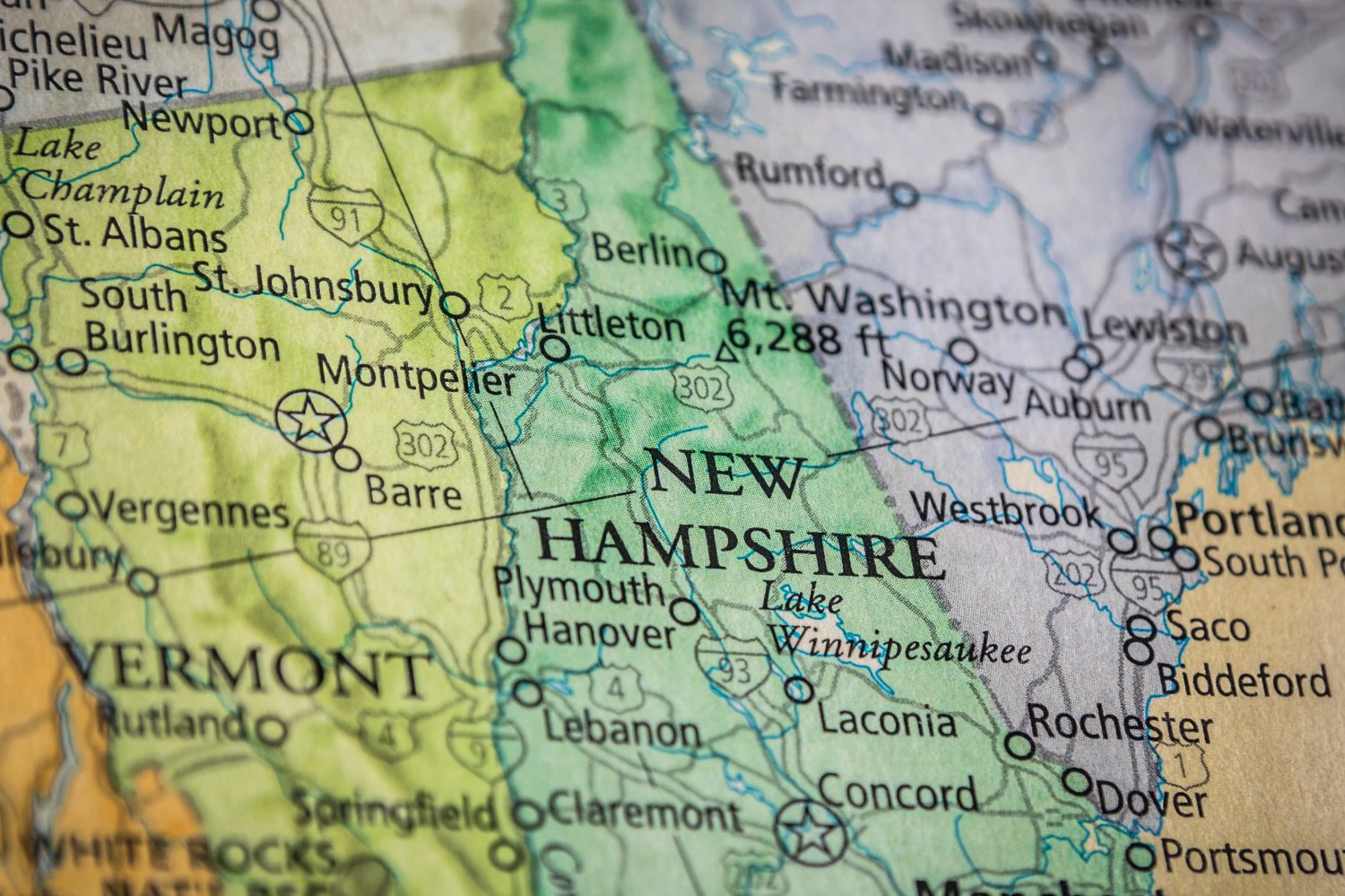 Primo piano del fuoco selettivo dello stato del New Hampshire su una mappa geografica e politica dello stato degli Stati Uniti.
