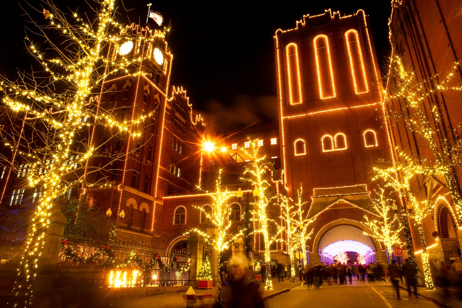 St Louis, Missouri, Stati Uniti d'America, dicembre 2019 - alberi decorati con luci di Natale Anheuser Busch Brewery storica torre dell'orologio inverno St Louis di notte