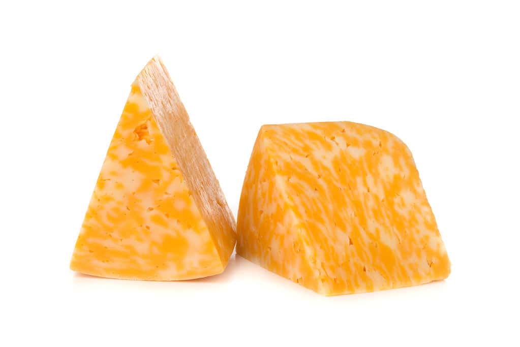 Formaggio di marmo su sfondo bianco.  Due triangoli di formaggio da vicino.