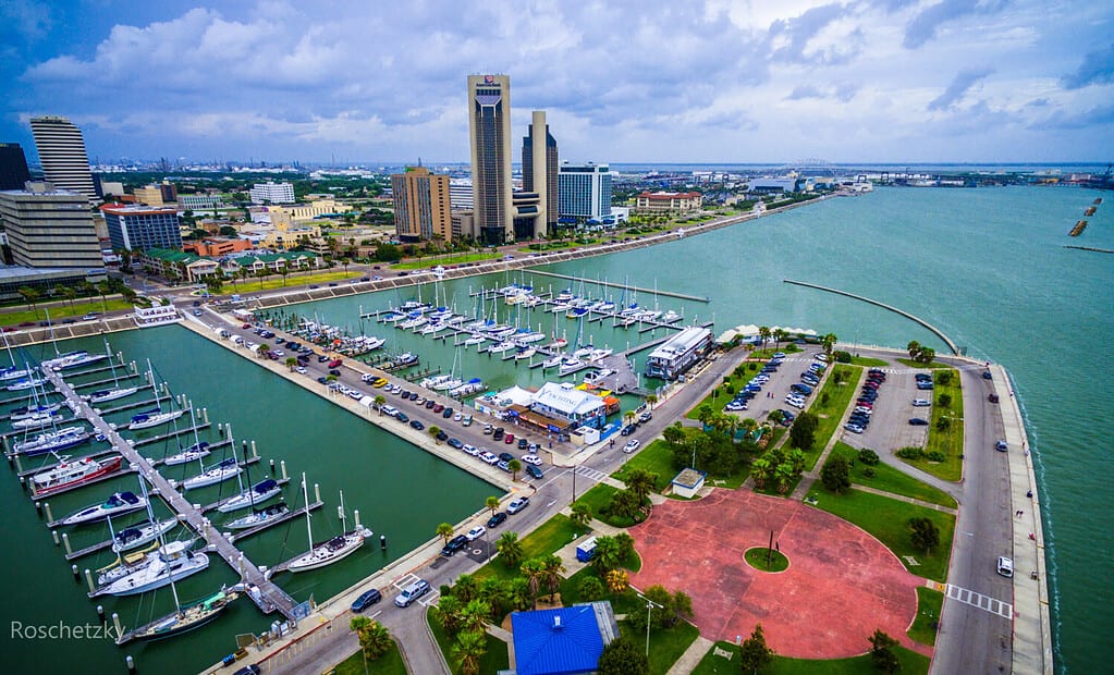 Corpus Christi Texas Skyline vista del ponte del porto della città sullo sfondo con molte file di moli pieni di barche, barche a vela e yacht attraverso la fuga di un punto di riferimento per le vacanze estive