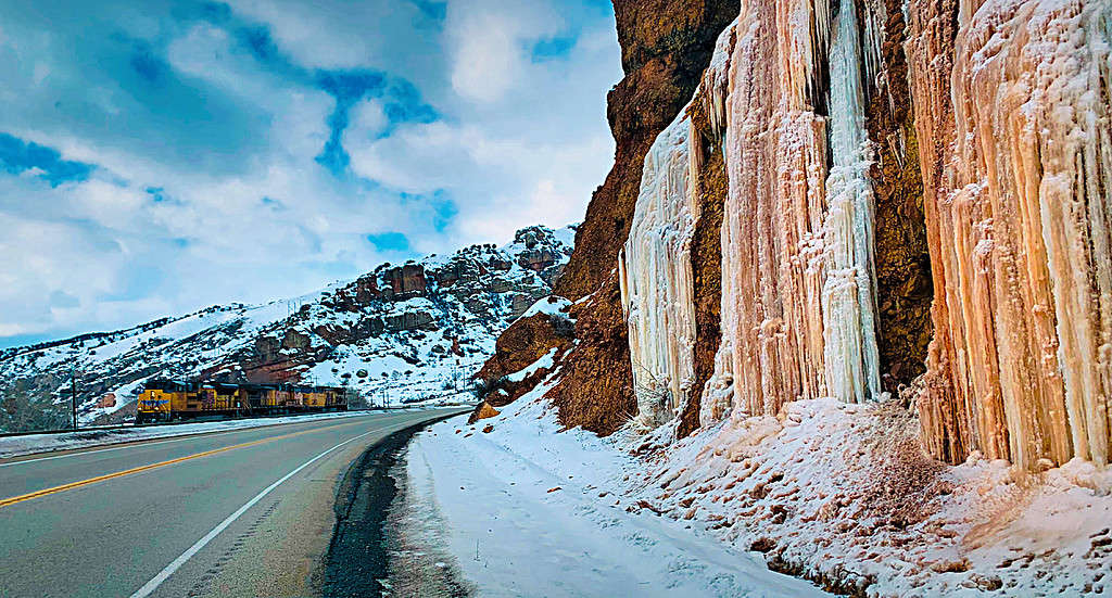 Bellissime formazioni di ghiaccio che scendono a cascata sulle scogliere dei libri lungo la strada - Foto Stock