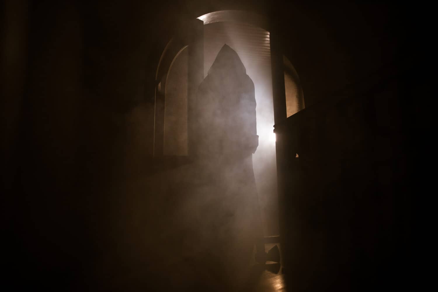 Silhouette di una figura ombra sconosciuta su una porta attraverso una porta di vetro chiusa.  Ragazza silhouette spettrale di notte con fumo sullo sfondo