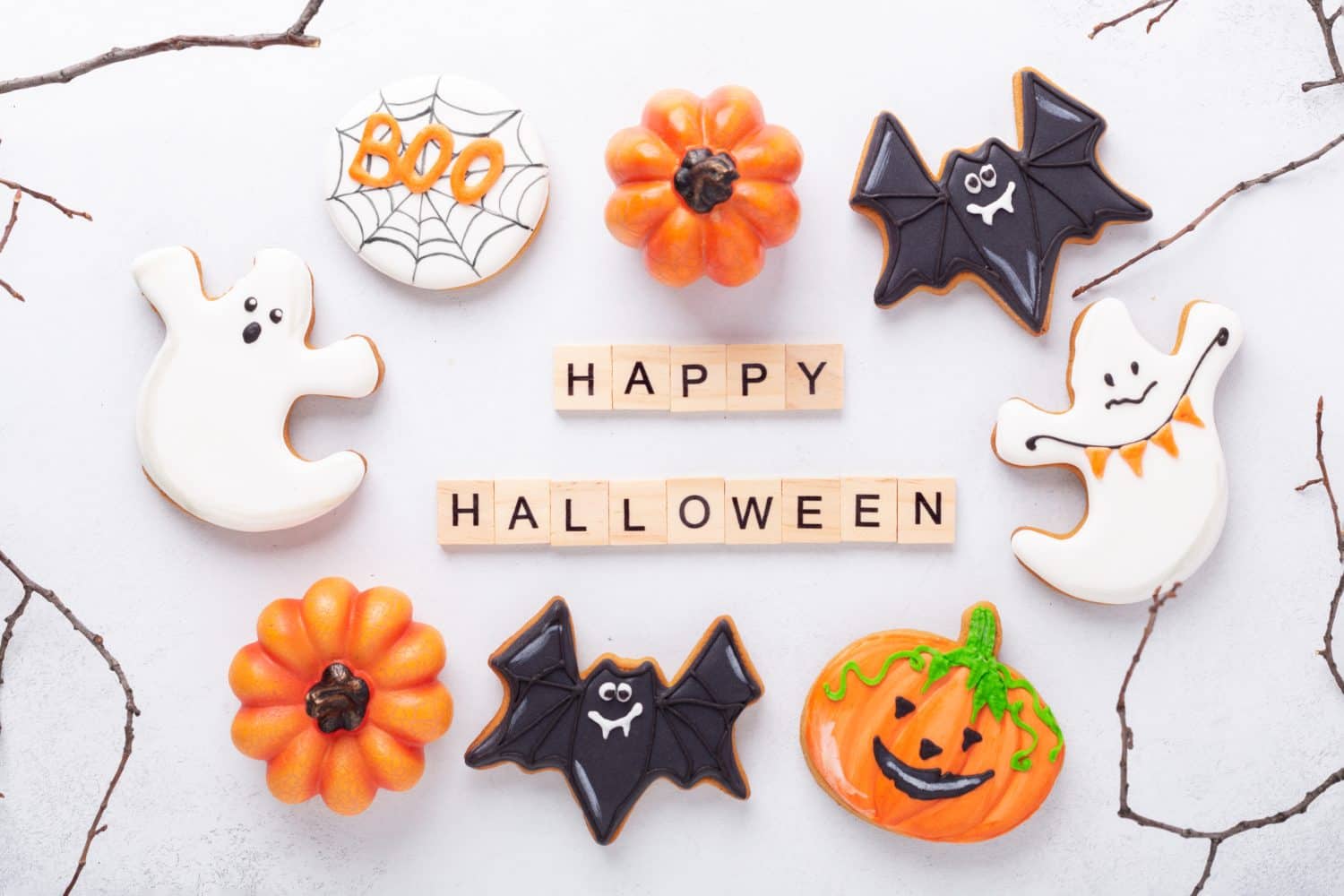 Insieme di vari biscotti di pan di zenzero e blocchi di legno Happy Halloween su sfondo bianco.  Biscotti fatti in casa luminosi per la festa di Halloween