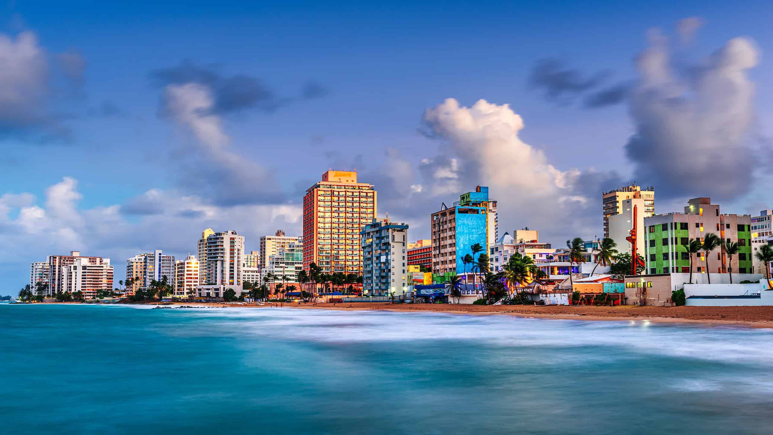 San Juan, Puerto Rico resort skyline sulla spiaggia di Condado al tramonto.