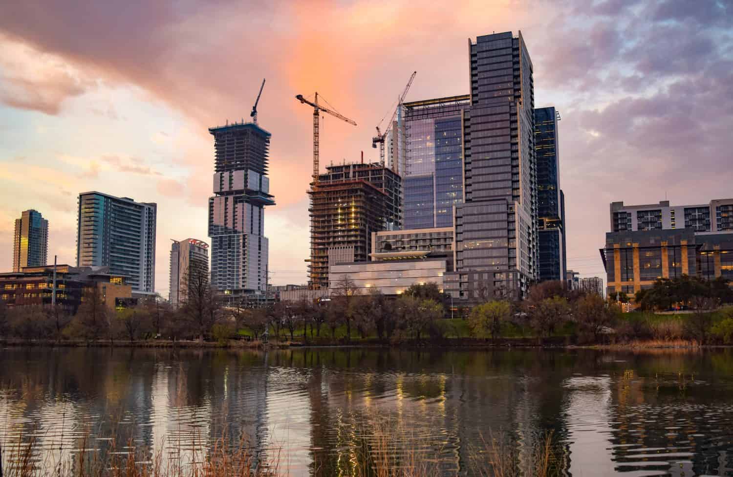 Una vista al tramonto delle gru edili che dominano lo skyline in forte espansione delle parti occidentali del centro di Austin, in Texas.  