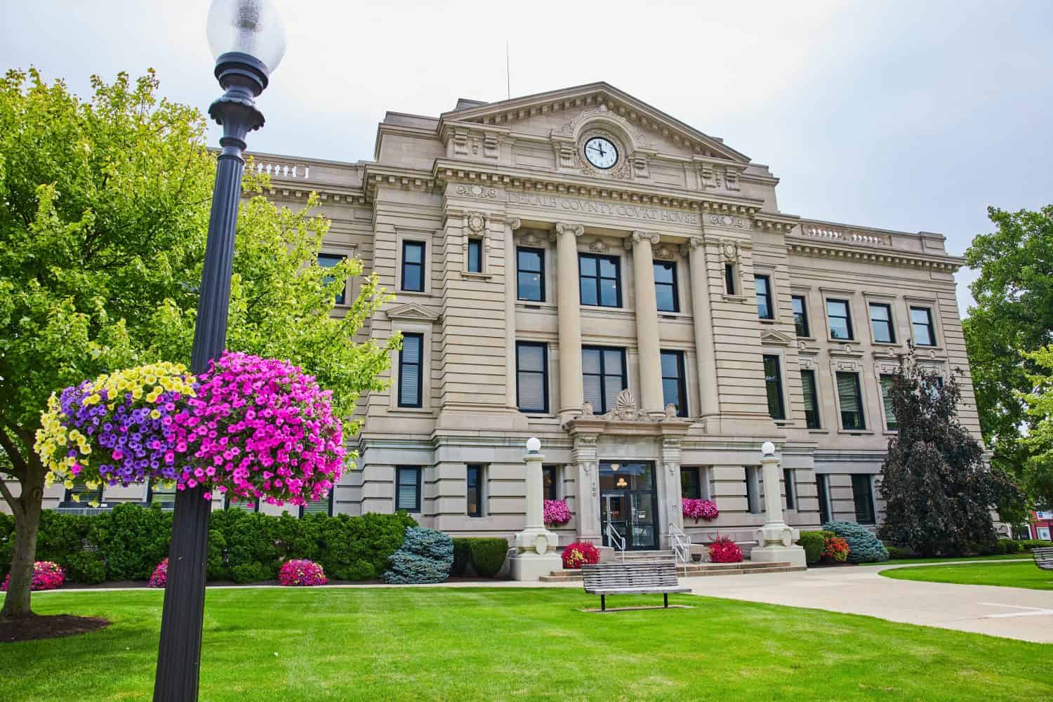 Ampia vista del tribunale della contea di Dekalb con fiori il giorno d'estate con l'orologio vicino a mezzogiorno