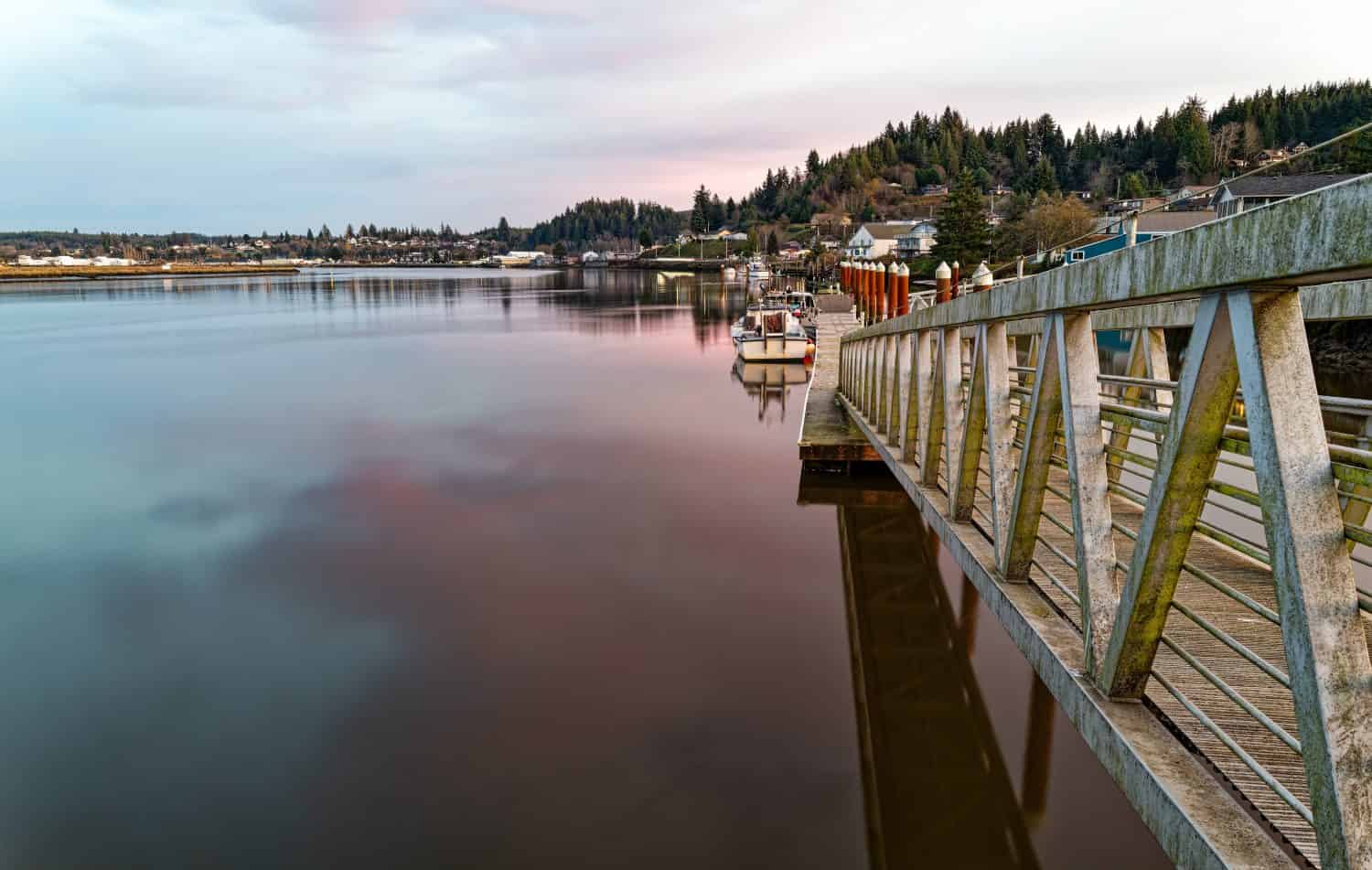 Dock per barche al tramonto sul fiume Willapa a South Bend, Washington, Stati Uniti d'America