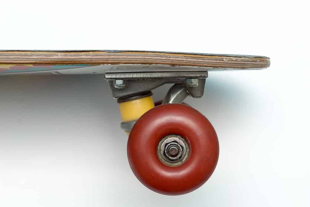 Skateboard.  Pensione da un centesimo.  Piccola tavola da crociera.  Tavola di legno.  Concetto di skateboard vintage.  Vista ravvicinata del penny board usato su sfondo bianco.