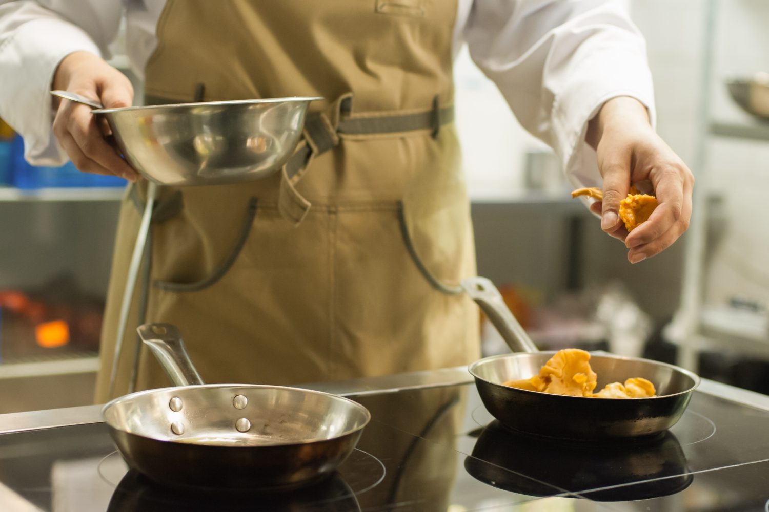 Chef professionista che cucina nel ristorante dell'hotel e prepara la cena.  Preparando il cibo.  Lo chef cucina i funghi finferli