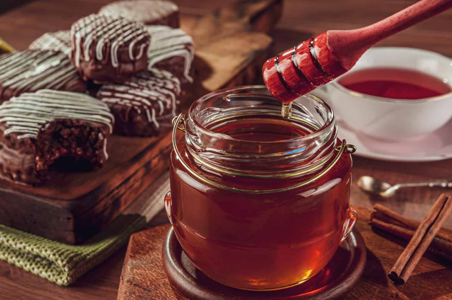 Primo piano dell'ape mellifera e del biscotto brasiliano al miele ricoperto di cioccolato - Pão de mel