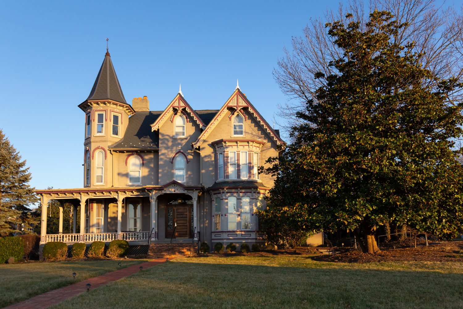 Bella casa in mattoni in stile vittoriano con dettagli in legno e torre vista durante un pomeriggio invernale d'ora d'oro, Harrisonburg, Virginia, Stati Uniti