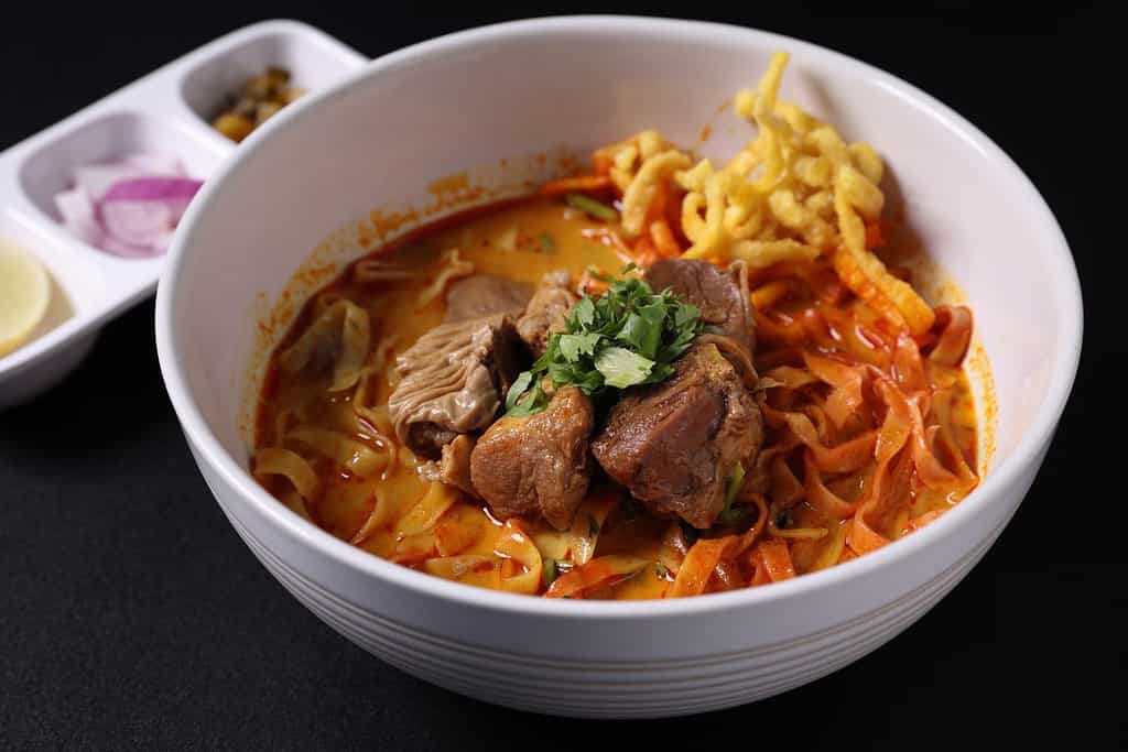 Zuppa di curry tailandese Khao Soi isolata su sfondo nero