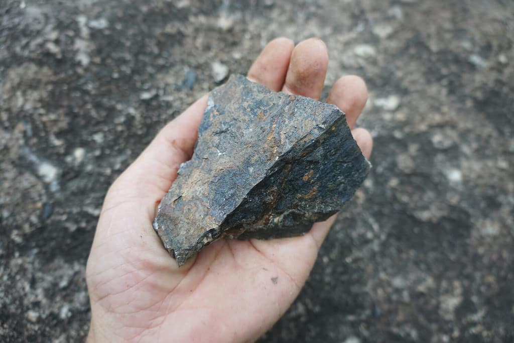 Una mano che tiene la pietra di ematite.  pietra di ferro.