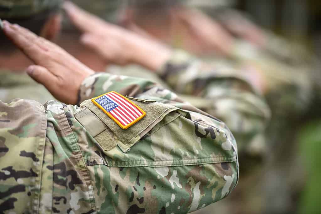 Dettaglio girato con la bandiera americana sull'uniforme del soldato, che fa il saluto d'onore durante la cerimonia militare