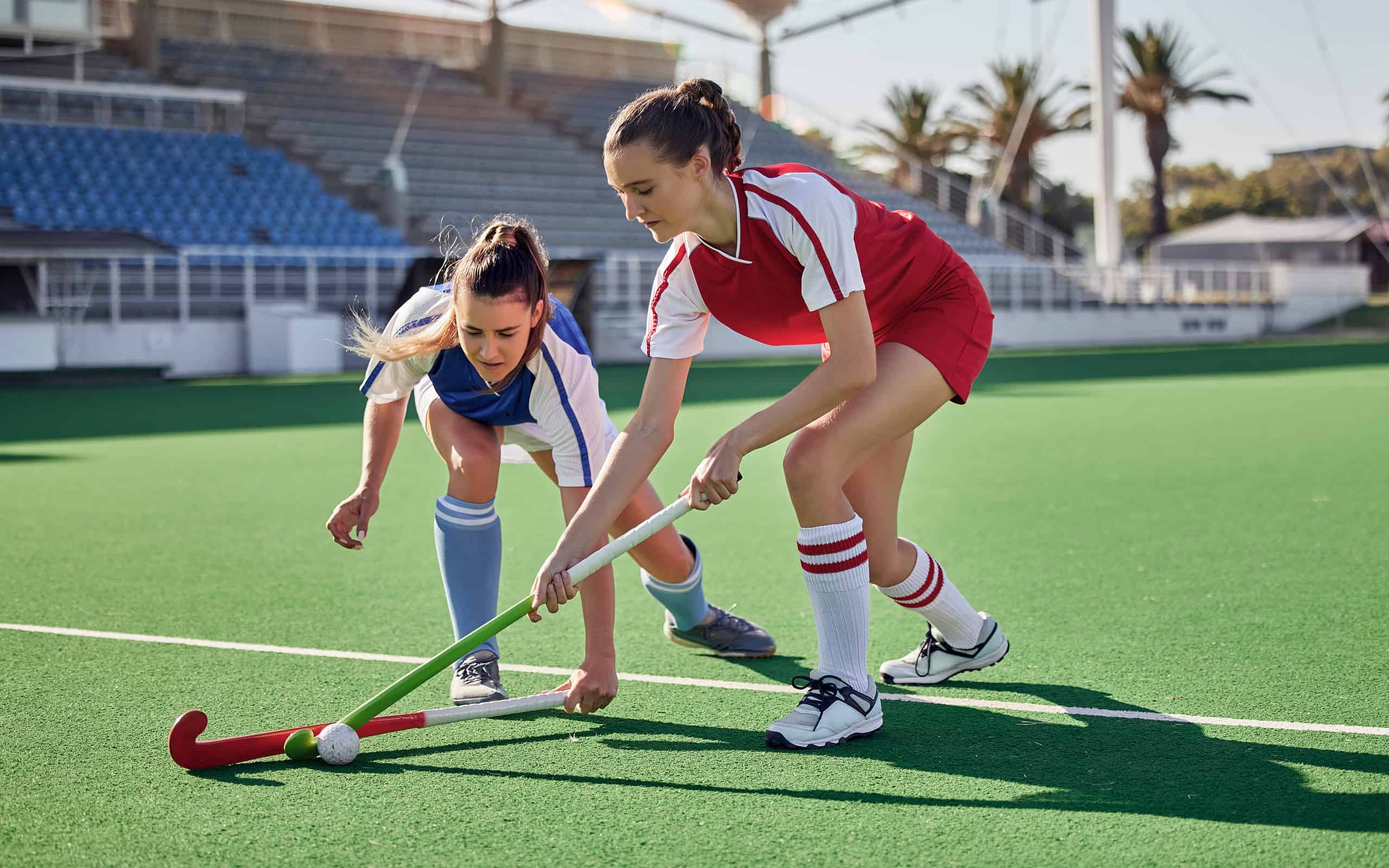 Due concorrenti si contendono la palla durante una partita di hockey su prato.