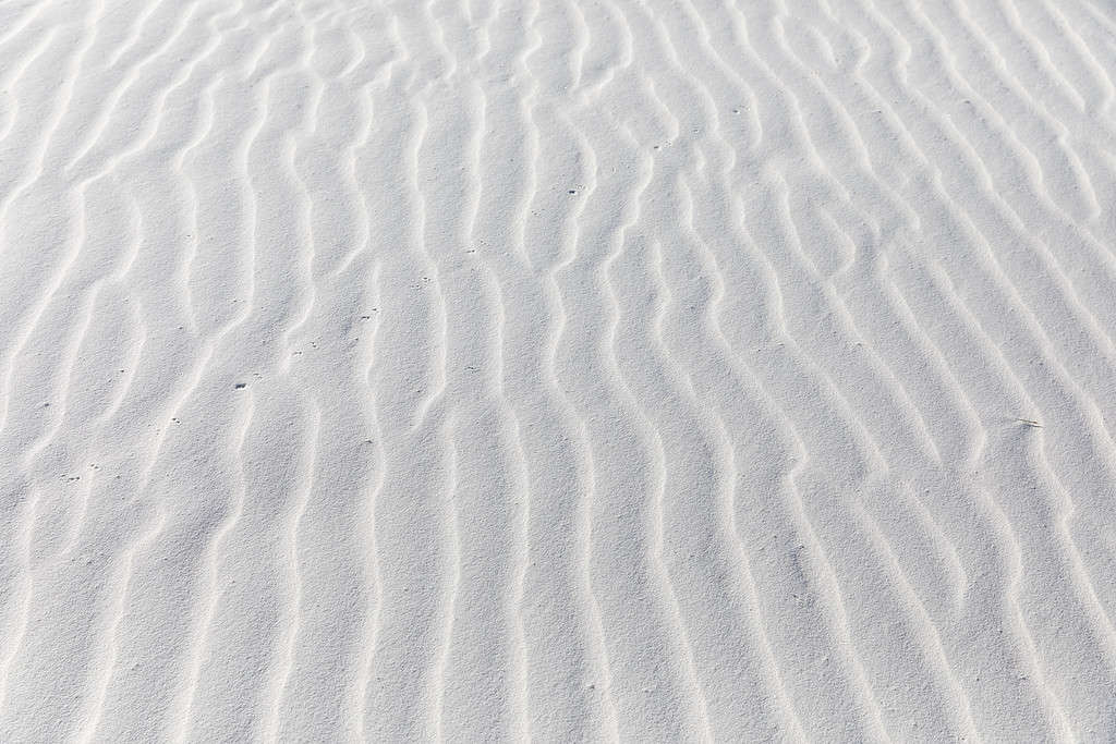 Primo piano dei motivi che il vento ha soffiato nella sabbia bianca