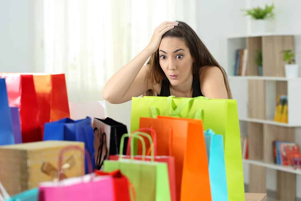 Donna sorpresa che esamina più acquisti