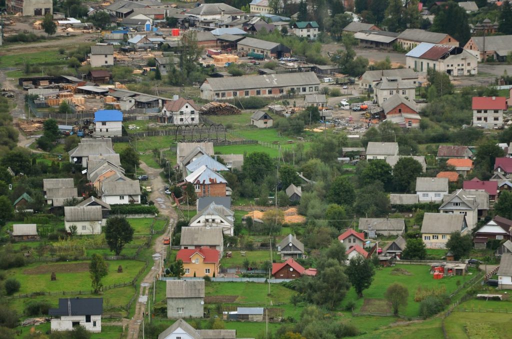 Una bellissima vista del villaggio di Mezhgorye, nella regione dei Carpazi.  Molti edifici residenziali circondati da alte montagne forestali e da un lungo fiume