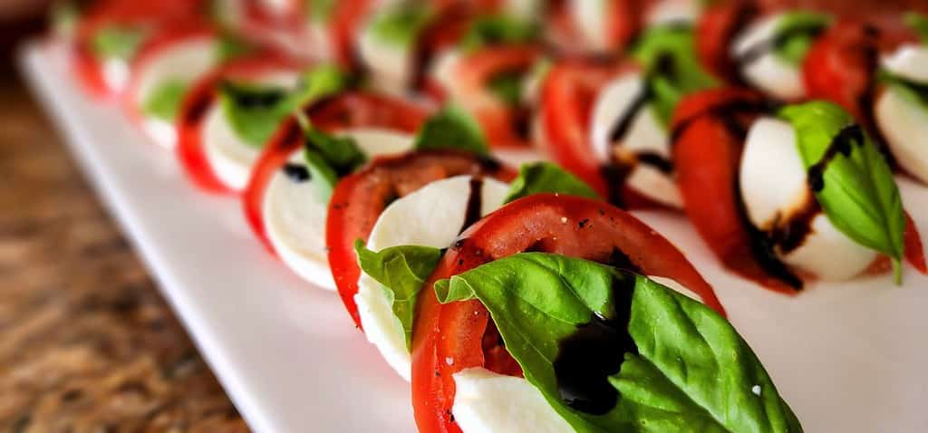 Delizioso antipasto di insalata caprese su un piatto da portata bianco